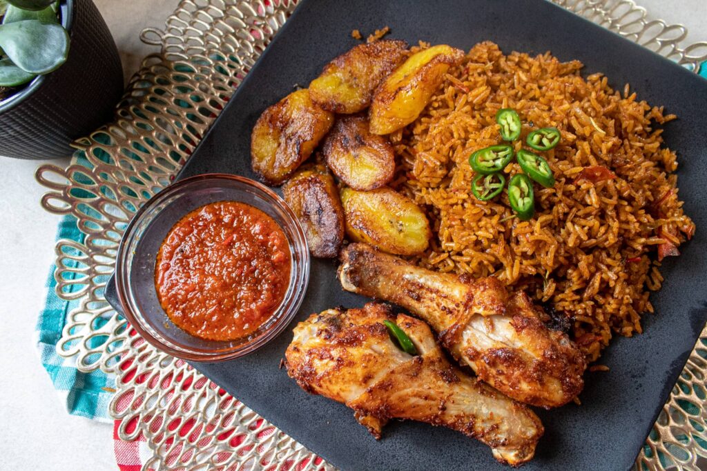 jollof rice with plantains, chicken and red sauce